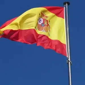 Bandera de España ondeando sobre un cielo azul